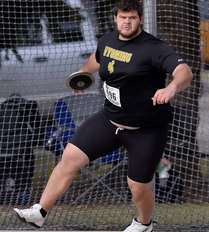 A discuss player that is fat, ready to throw in the discus.