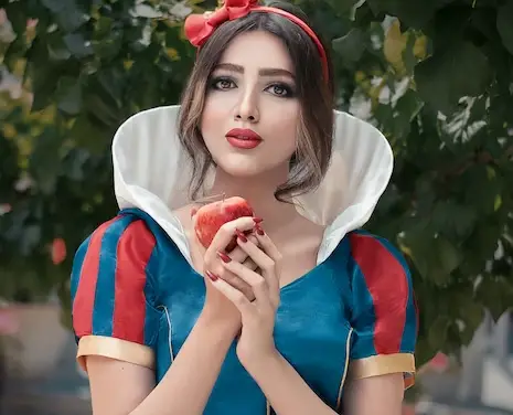 The beautiful snow white holding an apple.