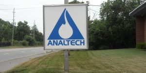 A sign board on the front yard of a company that says Analtech.