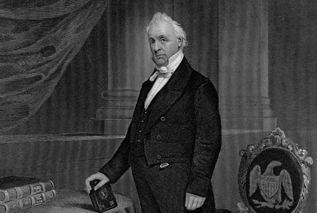 James Buchanan standing while holding a book on the table.