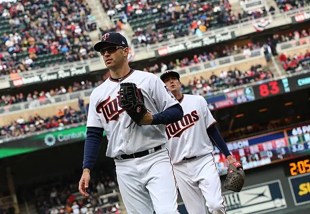 Two players of Minnesota Twins walking towards the field.