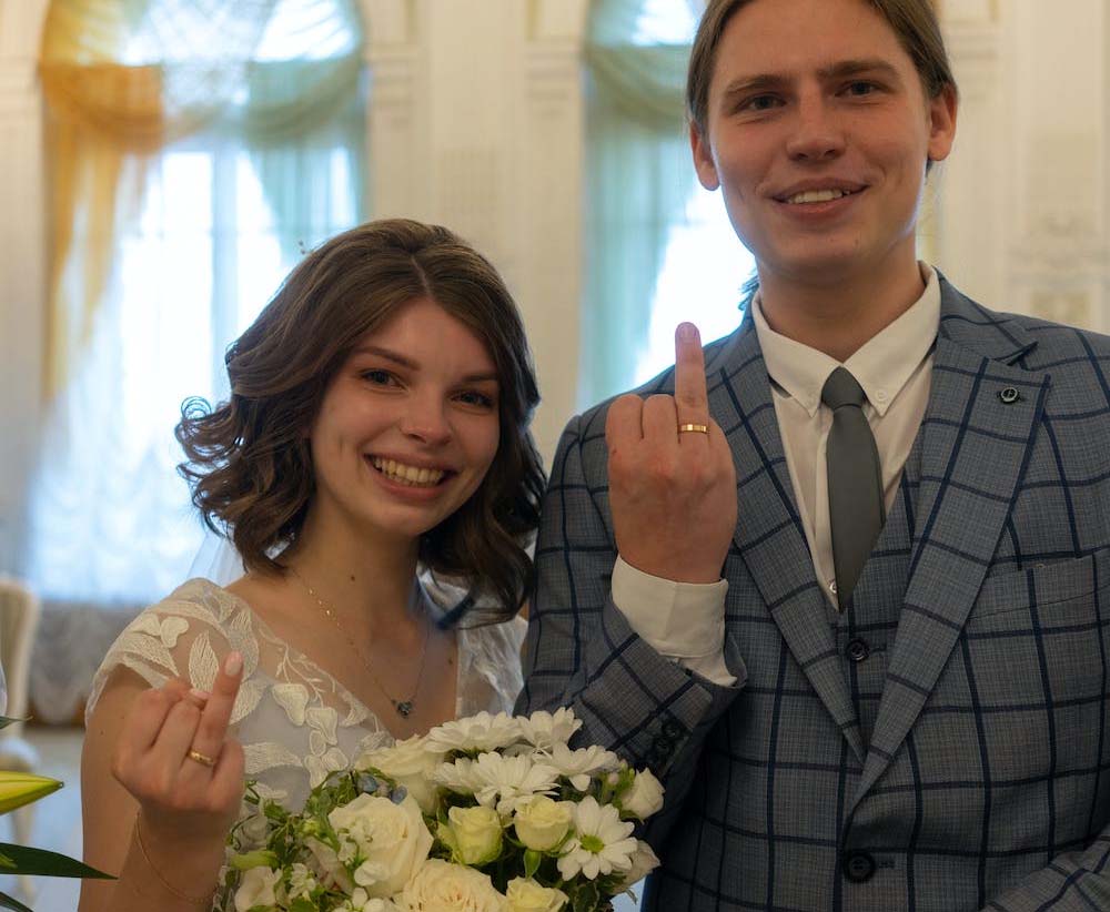 Two thirty year old couples getting married and showing their wedding ring in their ring fingers.