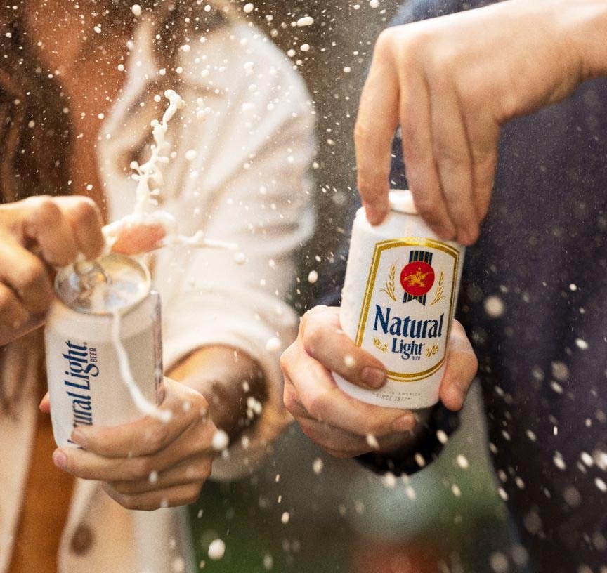 A couple each opening a can of Natural Light beer.