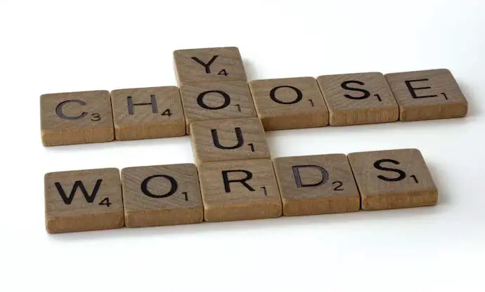 Words formed using scrabble tiles saying, choose your words.