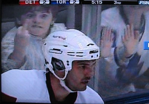 A hockey player flashed on screen with a spectator kid behind him sending the middle finger.