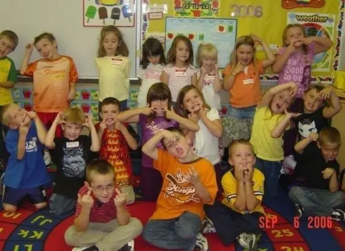 Kids doing wacky poses and one of them makes the middle finger sign.