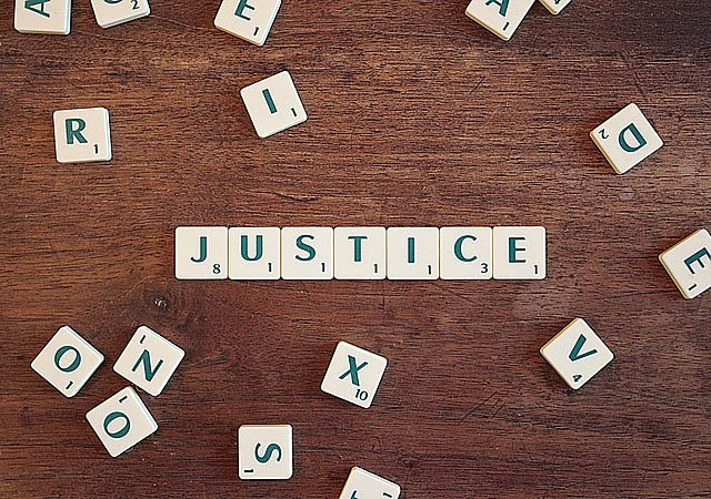 Scrabble tiles forming the word "JUSTICE"