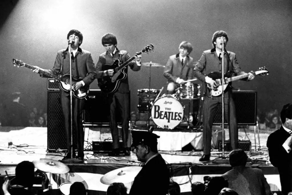 The Beatles playing on stage during a concert.