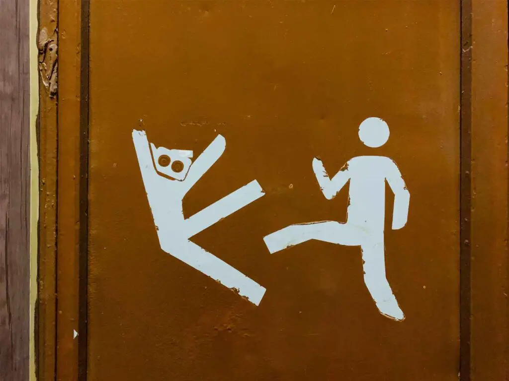 A drawing on the wall about a person kicking another guy.