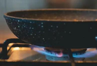A pan heating on a burning stove.