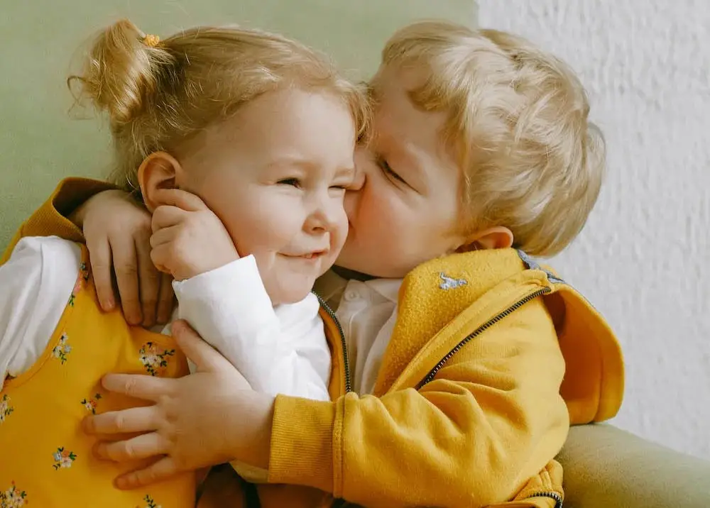 Two cute siblings wearing yellow jacket.