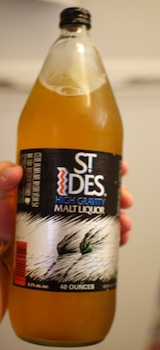 Holding a bottle of St. Ides high quality malt liquor brand.