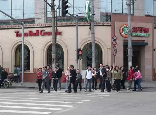 Chinese people crossing the pedestrian in front of Taco Bell Grande, a replica of the original Taco Bell restaurant in the U.S.