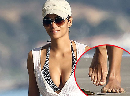 Halle Berry walking in a beach showing her eleven fingers.