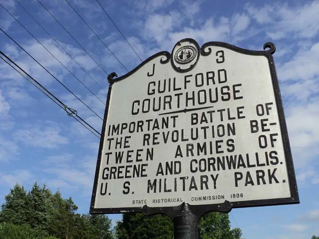 A historical sign about the Battle of the Guilford Courthouse that says, "Important Battle fo the revolution between armies of Greene and Cornwallis. U.S. Military Park.