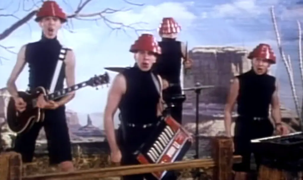 Devo with their black costume and red hat in their music video "Whip It."