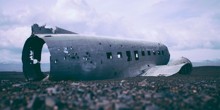 A broken fuselage remains of a commercial airplane after crashing.