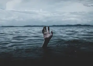 A hand of a drowning person sticking out of the water waiting for help.