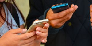 A man and a woman using their mobile phones.