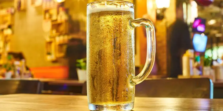 Glass of ice-cold beer on a table of a bar.