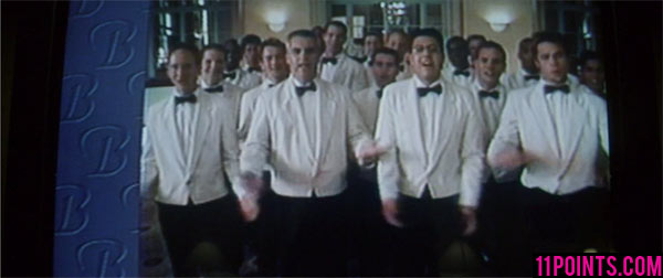 Tyler as being part of a group of waiter wearing white clothes with black bowtie and black slacks.