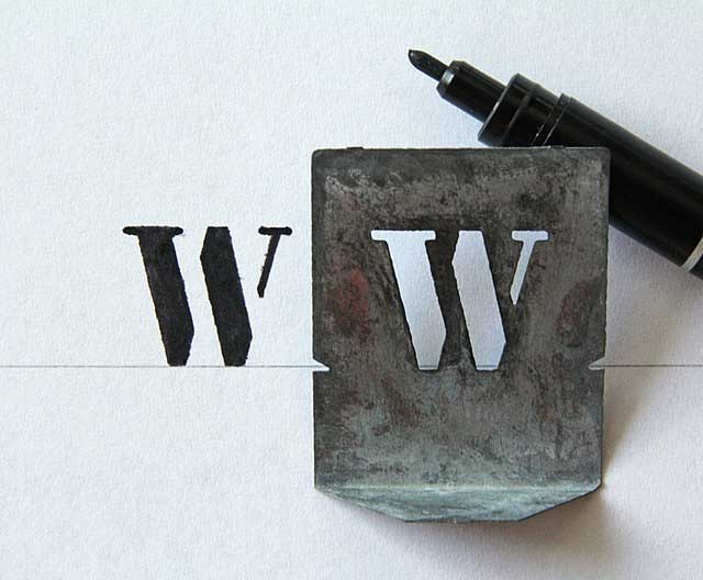Metal stencil for the letter W with the stencil plate and pen.