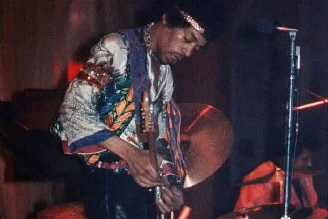 Jimi Hendrix playing guitar on stage.
